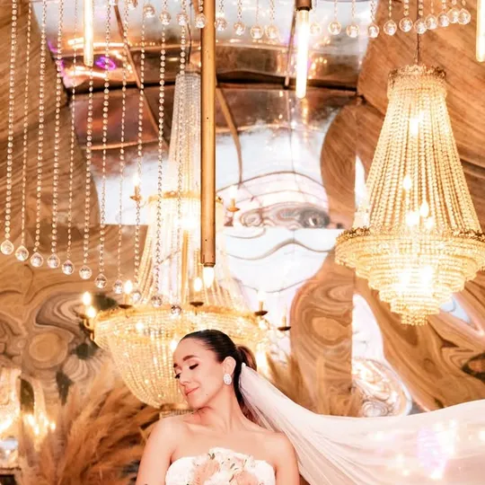 Novia con velo bajo los candelabros